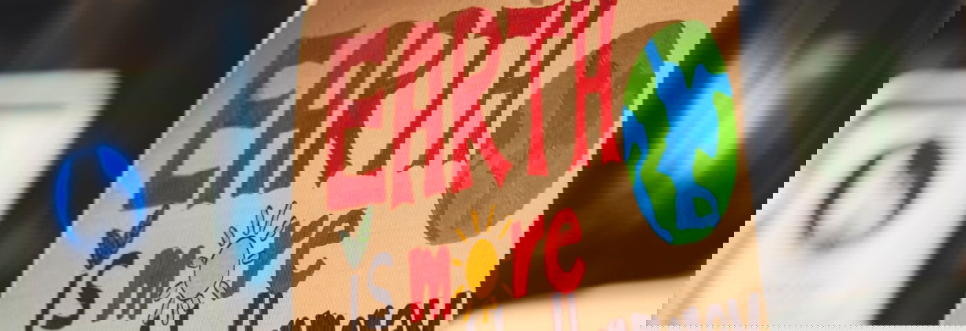 Klimaatprotest bord met daarop de tekst: earth is more valuable than money