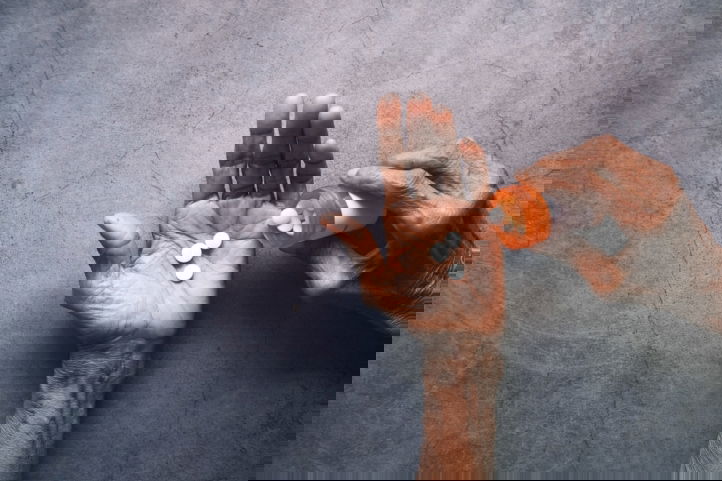 Handen die medicatie vasthouden