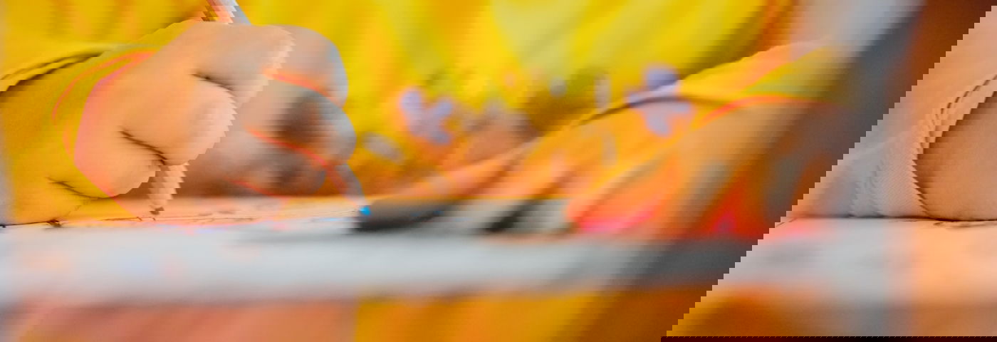 Kind tekent met kleurpotlood