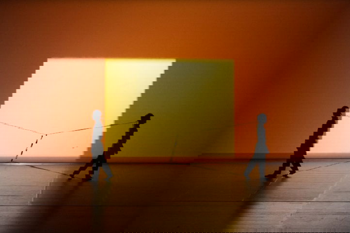 twee personen lopen draaien van elkaar weg maar blijven verbonden door draden