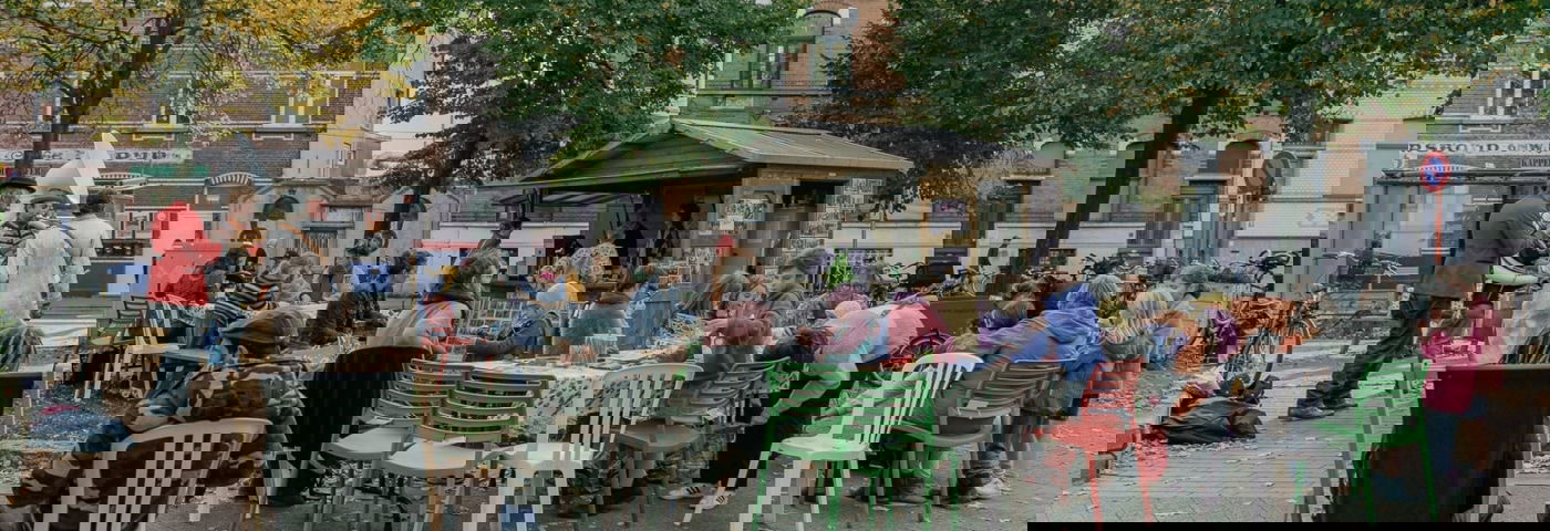 mensen zitten samen aan tafel op het seghersplein