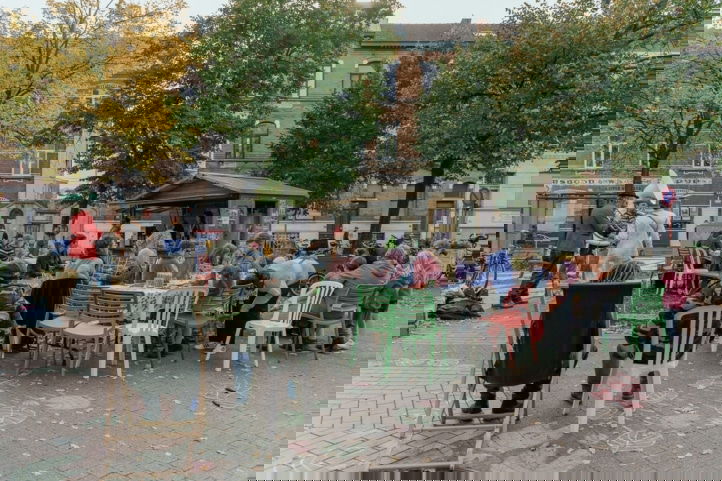 mensen zitten samen aan tafel op het seghersplein