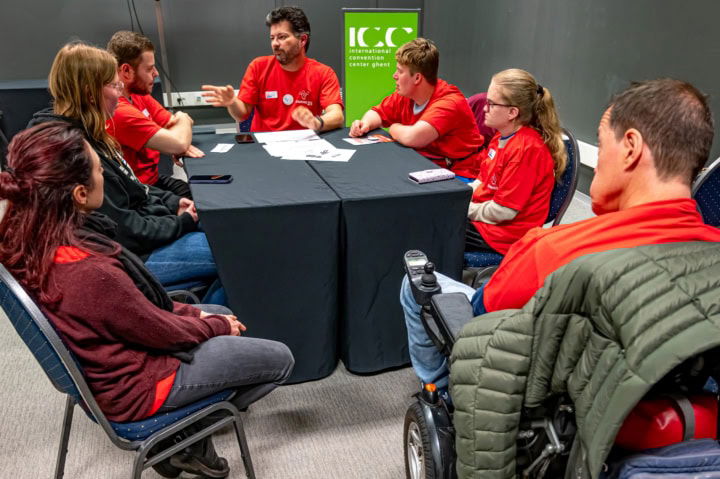 Vrijwilligers van het congres zitten samen rond de tafel met medewerkers van Konekt.